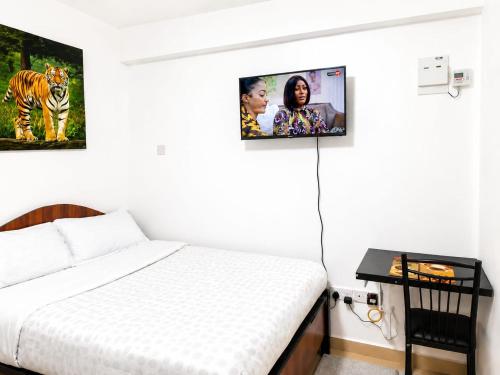 a bedroom with a bed with two pictures on the wall at Annie's studio near Westside mall in Nakuru