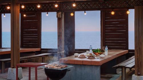 a table with food on it in a room with the ocean at Pohang Baritdol Pension in Pohang