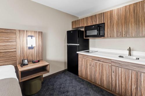 a small kitchen with a sink and a refrigerator at Quality Inn Ponca City in Ponca City