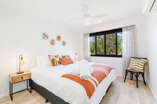 a bedroom with a large bed and a window at The Luxe Breeze Bungalow in Hervey Bay