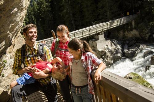 a group of people standing on a bridge with a baby at Gasthof Ambachhof in Oetz
