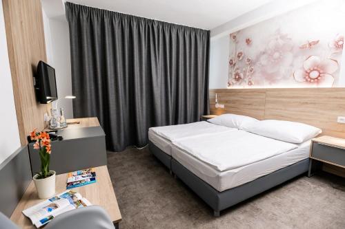 ein Schlafzimmer mit Bett, Schreibtisch und Fernseher in der Unterkunft Ensana Spa Smrdáky in Smrdáky