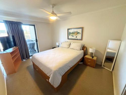 a bedroom with a bed and a ceiling fan at Jubilee Apartment 11 - Bring your own linen in South West Rocks