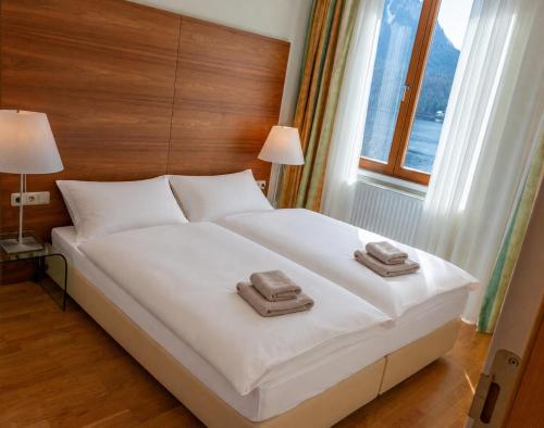 a bedroom with a bed with two towels on it at Seeappartement Altaussee - Your Austrian Home in Altaussee