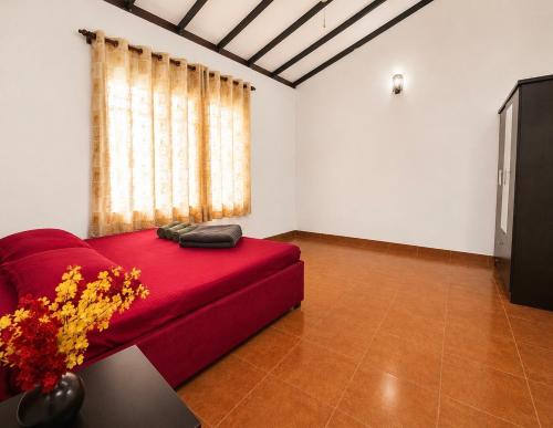 a living room with a red couch and a window at Sattvic Ceylon- Wellness Homestay in Colombo