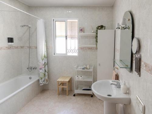 a white bathroom with a sink and a bath tub and a sink at Casa Paco & Carmela in Algodonales