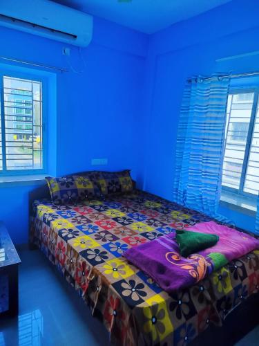 a bedroom with a bed in a blue room at Priya guest house in Howrah