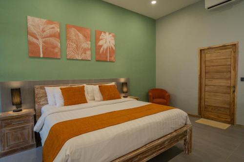 a bedroom with a bed and three paintings on the wall at Blue Marlin Dive Gili Air in Gili Islands