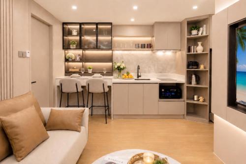 a living room with a couch and a kitchen at 1BR Solice Apartment Capri in Ban Thalat Choeng Thale