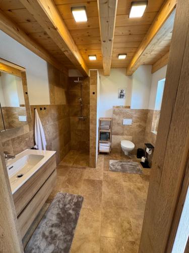 a large bathroom with a tub and a sink at Alpenchalet Sonnberg in Kalwang