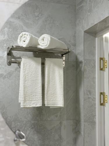 a bathroom with towels on a towel rack with a mirror at Karibi in Kyzylorda