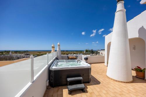 a hot tub on the roof of a house with two lighthouse at Casa Alvor in Alvor
