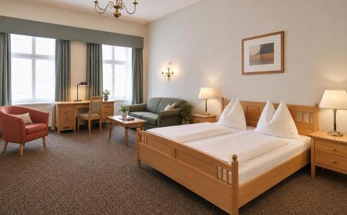 a hotel room with a large bed and a chair at DORMERO MaHo Steyr in Steyr