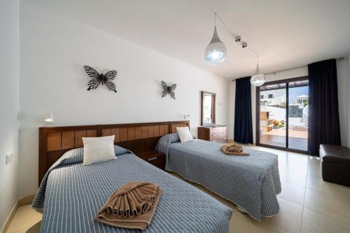 a bedroom with two beds and a living room at Villa Turquesa in Playa Blanca