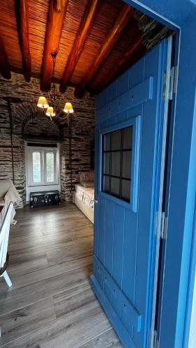 a blue door in a room with a wooden floor at The Kamaraki Project in Kórthion