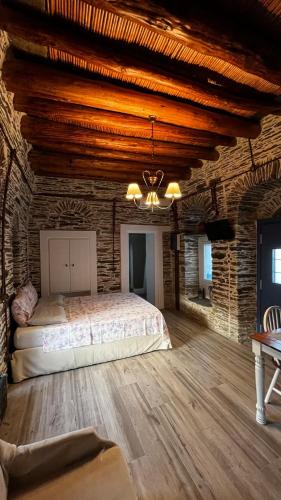 a bedroom with a bed and a brick wall at The Kamaraki Project in Kórthion