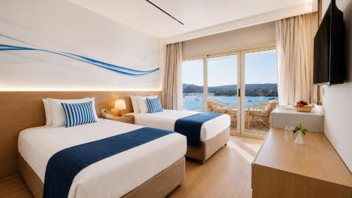 two beds in a hotel room with a view of the water at Obelisk Nile Towers in Aswan