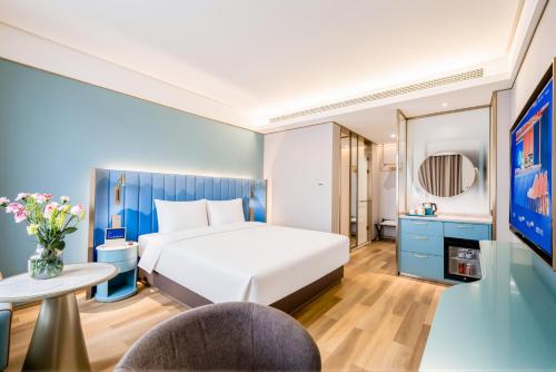 a hotel room with a bed and a table at Manxin Hotel Suzhou Jinfeng Road in Suzhou