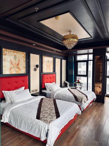 a bedroom with two beds and a chandelier at 伟信名人酒店 in Sihanoukville