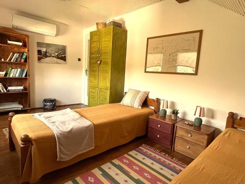 a bedroom with a bed and a book shelf at Sziget Gyöngye Vendégház in Tahitótfalu