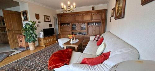 a living room with a white couch and red pillows at FeWo Christa in Marpingen