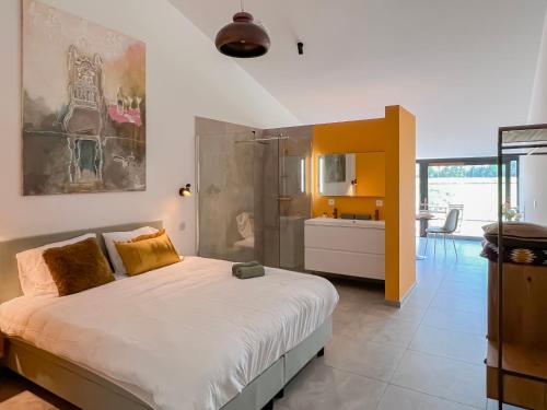 a bedroom with a large bed and a kitchen at Whaaw Herentals in Herentals