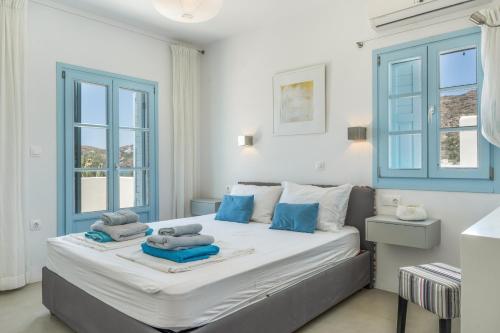 a bedroom with a large bed with blue accents at Beachfront Ios Villa in Ios Chora