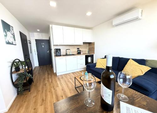 a bottle of wine sitting on a table in a living room at Sky View Apartmán 10 patro in Břeclav