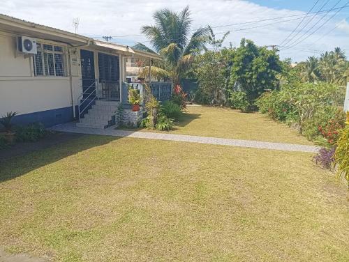 a house with a grass yard in front of it at Mishra Residence in Suva