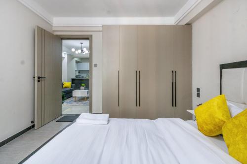 a bedroom with a large white bed with yellow pillows at Kindaruma Homes Apartments in Nairobi