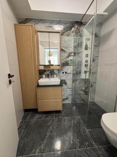 a bathroom with a sink and a shower at Olive II Apartman in Alsóörs