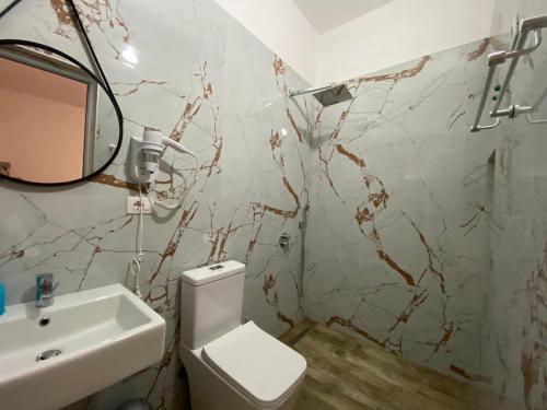 a bathroom with a white toilet and a sink at Gray&Oli Studios in Vlorë