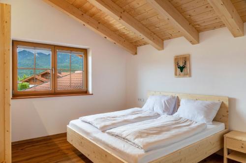 a bedroom with a bed and a window at Haus Stoabock in Wallgau