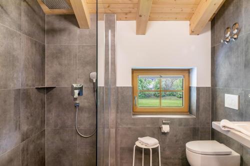 a bathroom with a shower and a toilet and a window at Haus Stoabock in Wallgau
