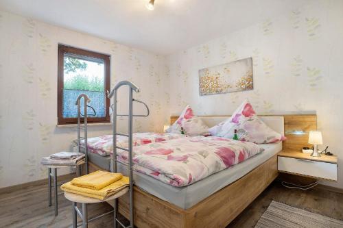 a bedroom with a bed and a desk and a window at Ferienhaus Cajo in Dahmen
