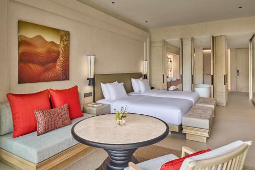 a hotel room with a large bed and a table at THE BARAI HUA HIN - The Unbound Collection by Hyatt in Hua Hin