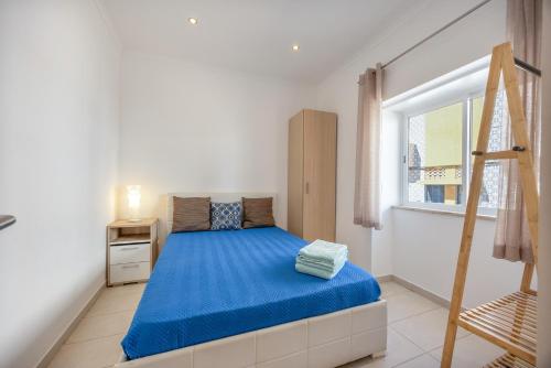 a bedroom with a bed with blue sheets and a ladder at Lanzarote Villa in Alvor