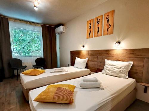 a hotel room with two beds and a window at Hotel Sorbona in Varna City