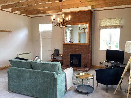 a living room with a couch and a fireplace at The Studio Cottage in Knock