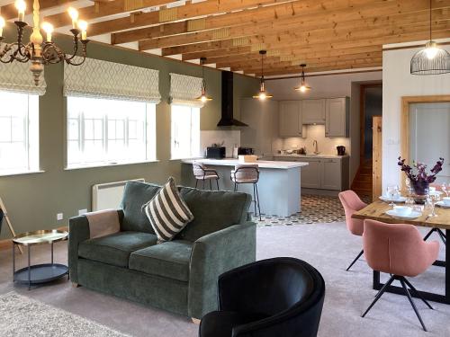 a living room with a couch and a kitchen at The Studio Cottage in Knock