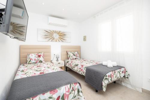 two beds in a room with white walls at Apartamento Lliteras 2C Ref 9003 in Cala Millor