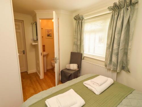 a bedroom with a bed with two towels on it at Rose Briar Cottage in Morpeth