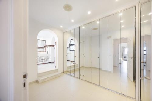 a dressing room with mirrors and white walls at Finca Isla Verde in Chipiona