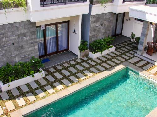 a house with a swimming pool in front of a house at Mimpi Ayung Villas by AGATA in Bringkit