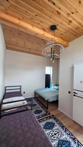 a bedroom with two beds and a wooden ceiling at Elida Guest Rooms in Cholpon-Ata