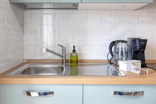 a kitchen sink with a bottle of wine on it at Appartamenti Da Ewa Valledoria in Valledoria