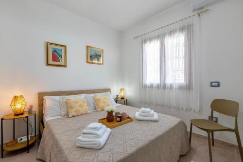 a bedroom with a bed with towels on it at Appartamenti Da Ewa Valledoria in Valledoria