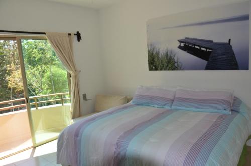 1 dormitorio con cama y ventana grande en Stay in Tulum!, en Tulum