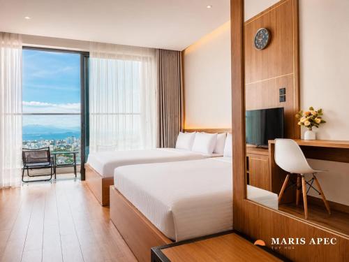 a hotel room with two beds and a television at Maris Apec Tuy Hoà in Tuy Hoa
