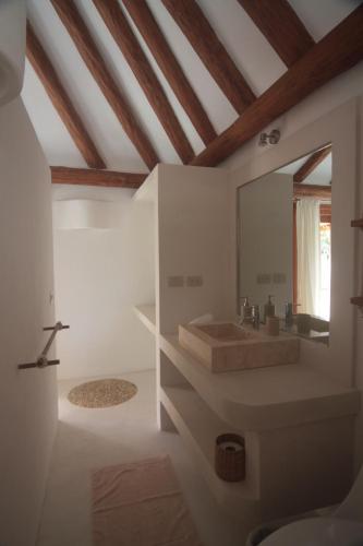 a bathroom with a sink and a mirror at Tierra del Mar Hotel - Adults Only in Holbox Island